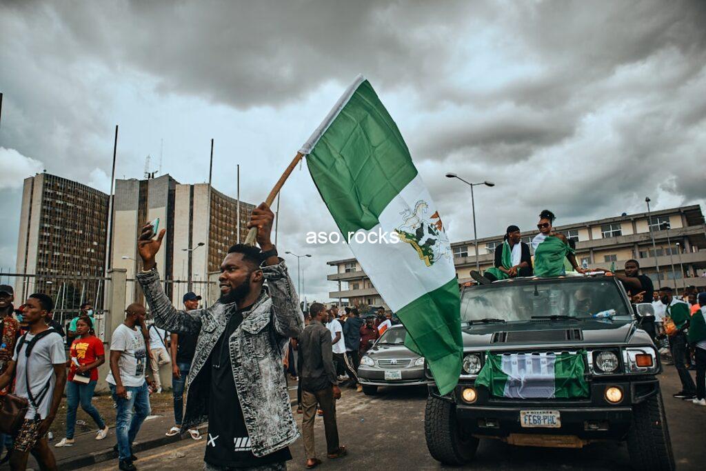 Nigerian man waving the Nigerian national flag in Port Harcourt, Nigeria — representing passionate Super Eagles and Nigerian football fan culture