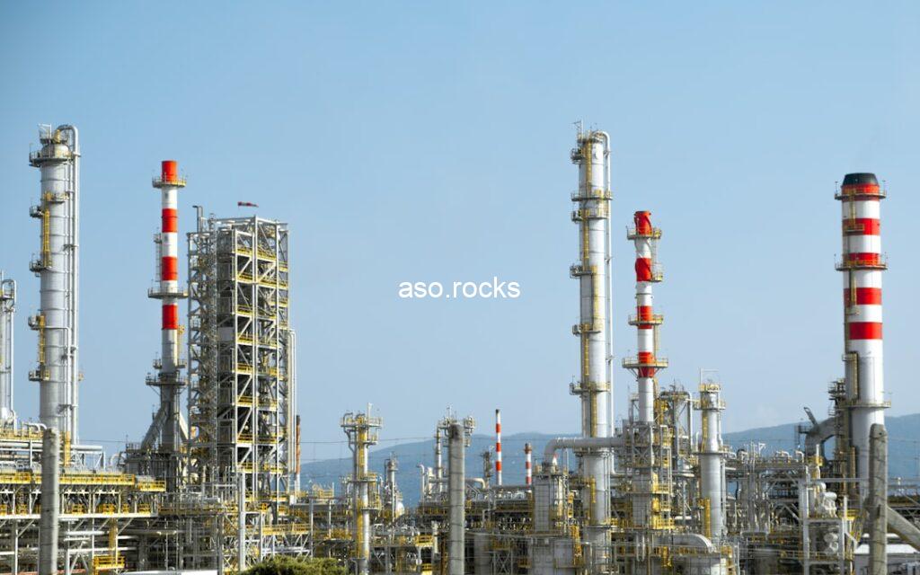 Oil refinery with tall processing towers and pipelines, representing Nigeria's crude oil production that drives naira exchange rate movements